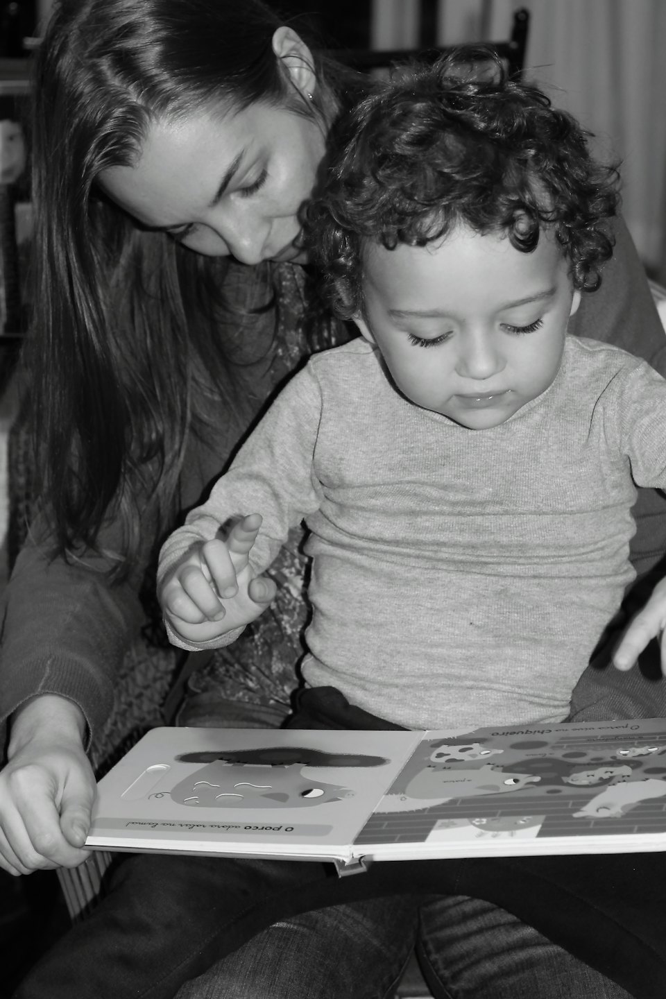 Donna e bambino leggono un libro insieme a casa.